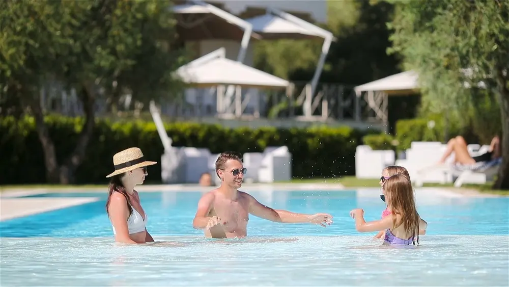 Familia disfrutando junta de una piscina